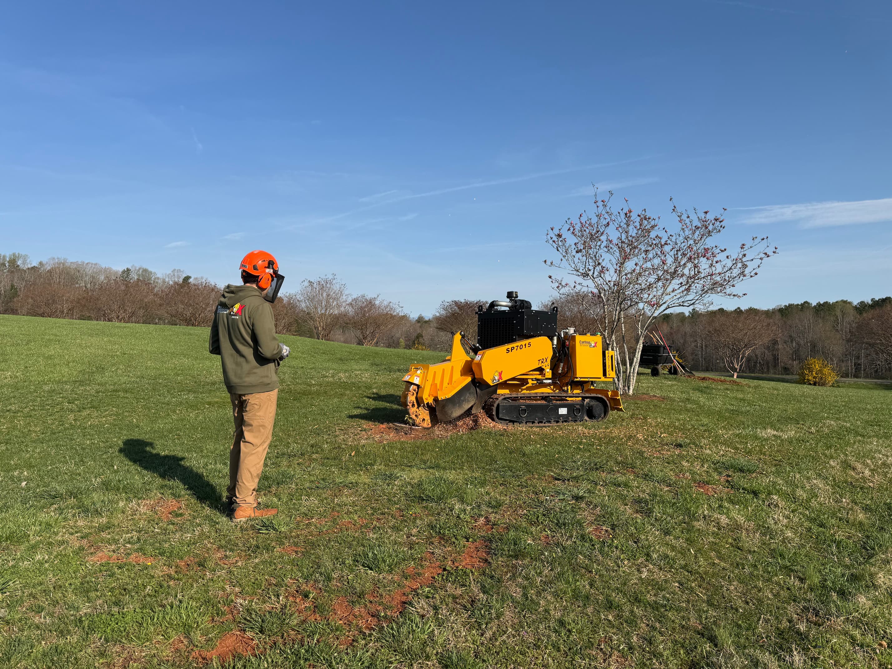 Foothills Stump Grinding operator running the tracked stump grinder on a rural property